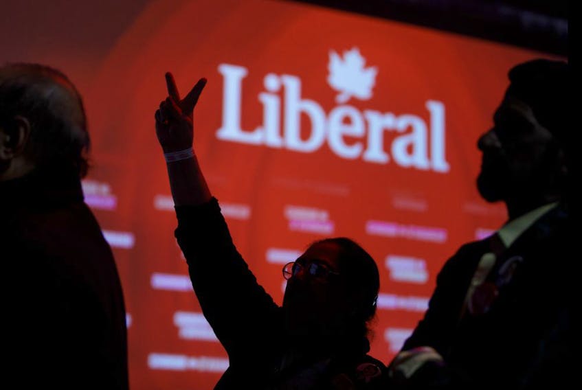 Liberal party supporters flash victory signs while watching the federal election results at the Palais des Congres in Montreal on Oct. 21, 2019. 