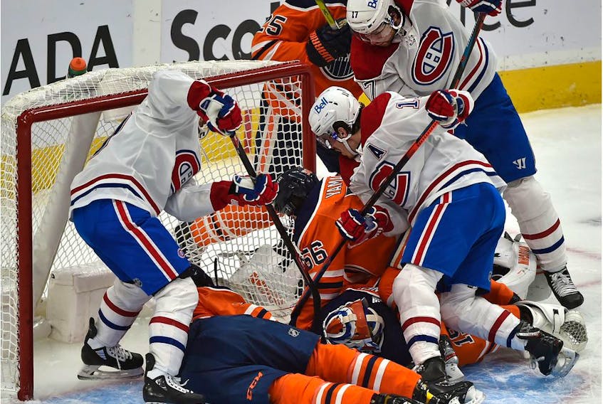 Montreal Canadiens players crowd the Edmonton Oilers' net and goalie Mikko Koskinen trying to jam in the puck at Rogers Place in Edmonton on Jan. 18, 2021. 
