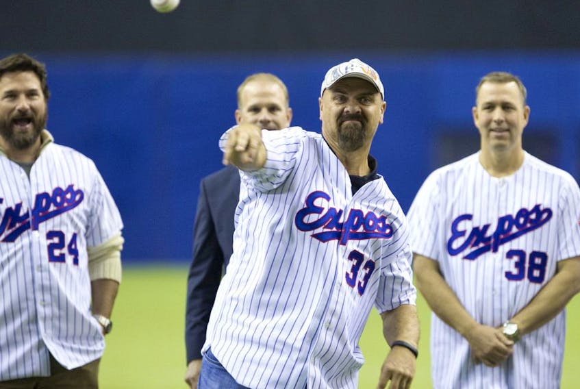  Former Montreal Expo Larry Walker throws a pitch as Darrin Fletcher, left, and Denis Boucher watch while taking part in a pre-game ceremony to honour the 1994 team before a pre-season exhibition game between the Toronto Blue Jays and the New York Mets at the Olympic Stadium in Montreal on March 29, 2014.
