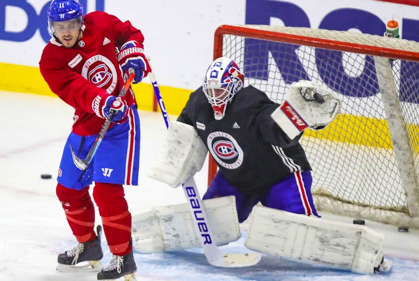 Jake Allen makes a glove save behind screen by Brendan Gallagher during Montreal Canadiens practice at the Bell Sports Complex in Brossard on Jan. 27, 2021. 