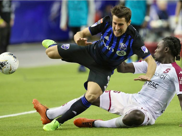 Montreal Impact midfielder Bojan trips over Deportivo Saprissa's Aubrey David during second half of the CONCACAF Champions League game at Olympic Stadium in February. 