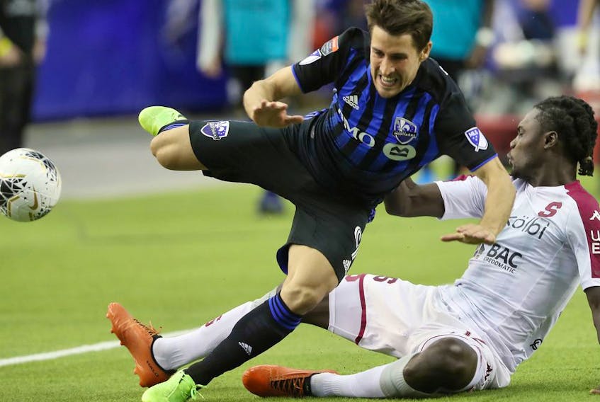Montreal Impact midfielder Bojan trips over Deportivo Saprissa's Aubrey David during second half of the CONCACAF Champions League game at Olympic Stadium in February. 