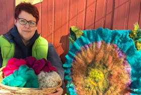 Deborah Johnson of Alma, N.S., displays a basket of wool roving and her intricately felted wall hanging of a poppy.