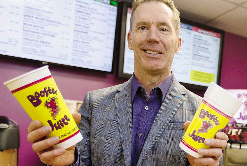 Booster Juice co-founder, president and CEO Dale Wishewan poses for a photo with the company's new cup (left) and old cup in the Booster Juice Test Kitchen at AW Holdings Corp.'s head office in Edmonton on Friday, January 27, 2017. 