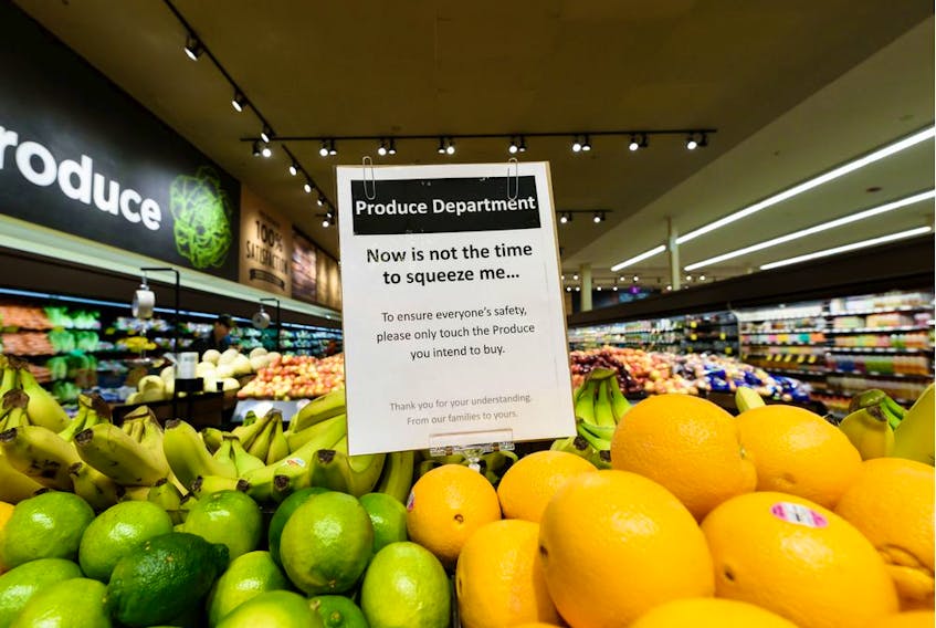 As a part of the COVID-19 safety efforts at Beltline Safeway a sign at the produce section asks customers to only touch what they intend to buy on Thursday, April 2, 2020. Azin Ghaffari/Postmedia