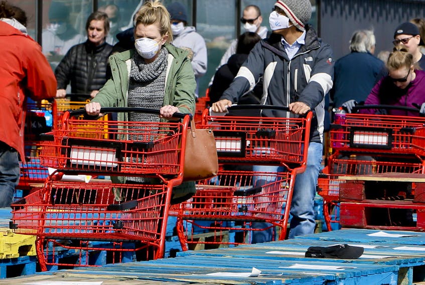 Due to COVID-19, shoppers line up in front of Loblaws, separated in rows by stacked wooden pallets on Thursday April 9, 2020 at the Leslie St location in Toronto. 