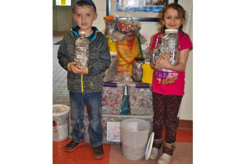 Corbin MacDonald and Kalie Cameron are shown with the pop tabs collected by students at A.G. Baillie Memorial School, which will be recycled with the money received used to buy a wheelchair for MacDonald, who has spinal muscular atrophy.