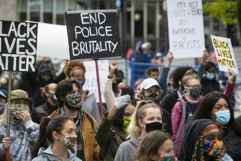 Protesters hold up signs during anti-racist and anti-police brutality demonstration on Sunday May 31, 2020. Most protesters are wearing mask for the COVID-19 pandemic (Pierre Obendrauf / MONTREAL GAZETTE) 
