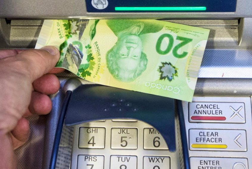 Money is removed from a bank machine Monday May 30, 2016  in Montreal.