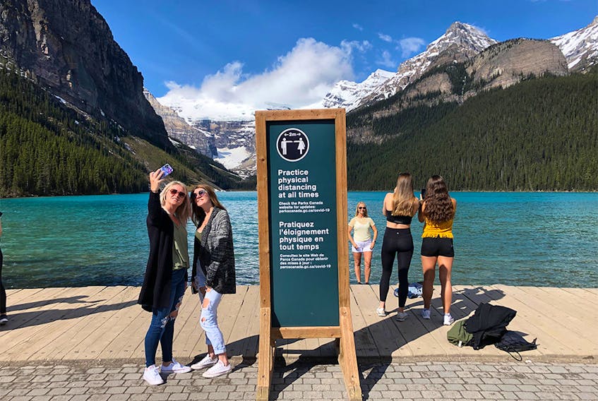 Tourists take photographs at Lake Louise on Friday, June 12.