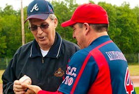 Island baseball legend Vern Handrahan, left, gets the opening-pitch ball back from catcher Craig Cooper of the host Chevies team during the opening ceremonies of the Canadian Oldtimers Baseball Championships at Memorial Field in Charlottetown Thursday, Aug. 2.