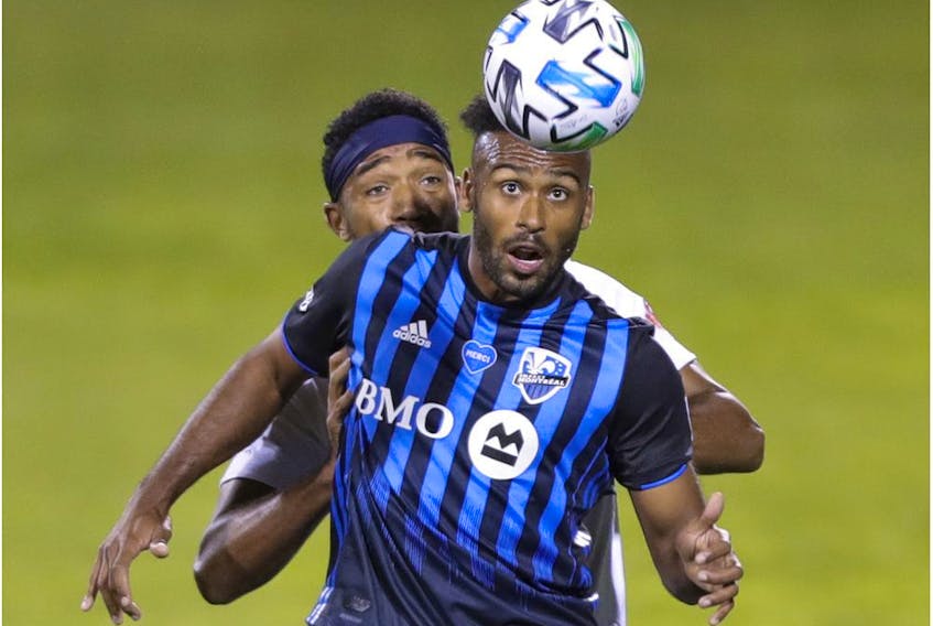 Impact's Anthony Jackson-Hamel heads the ball in front of Whitecaps defender Derek Cornelius during MLS game at Saputo Stadium in August. The homegrown striker was let go by Montreal on Friday.