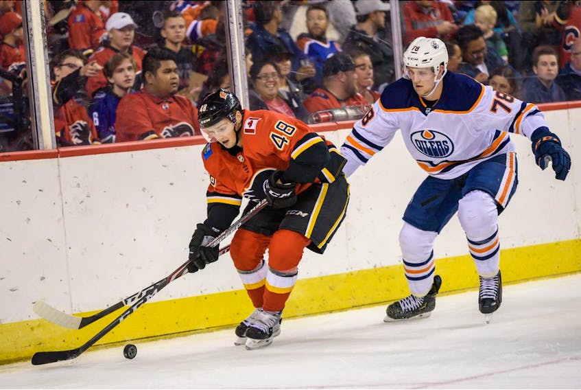 The Calgary Flames' Luke Philp and Edmonton Oilers' Dmitri Samorukov fight for the possession of the puck during the Battle of Alberta prospects game at Scotiabank Saddledome in Calgary on Sept. 10, 2019. Azin Ghaffari/Postmedia Calgary