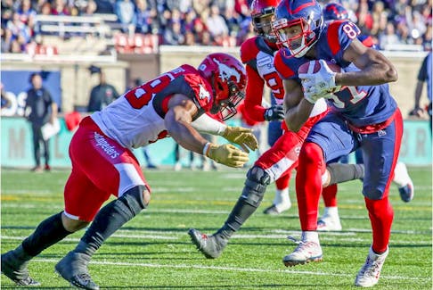  Alouettes receiver Eugene Lewis tries to avoid tackle by Stampeders’ Wynton McManis during game at Molson Stadium two weeks ago. Lewis, who needs 67 yards to reach 1,000, has never reached that milestone.