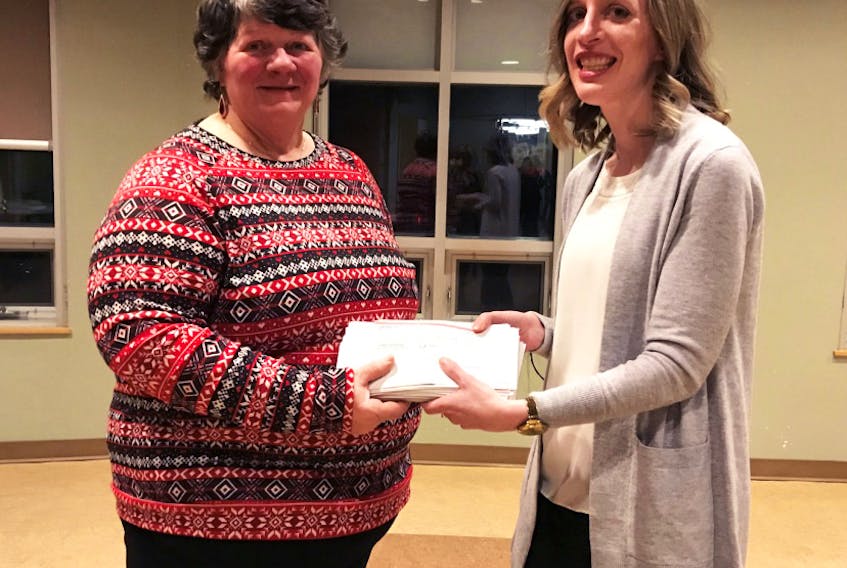 100 Women Who Care volunteer Nadia Tymczyszyn presents Anne Marie Long, from the Antigonish Town and County Palliative Care Society, with the group’s check at the end of their Dec. 5, 2018, meeting.