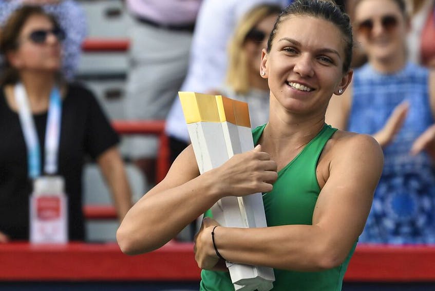 Simona Halep of Romania hugs the Rogers Cup championship trophy after defeating Sloane Stephens in the final at IGA Stadium on Aug. 12, 2018, in Montreal.
