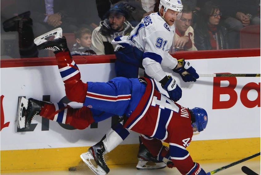  Canadiens centre Nate Thompson is sent to the ice by Lightning centre Steven Stamkos during play Tuesday night at the Bell Centre.