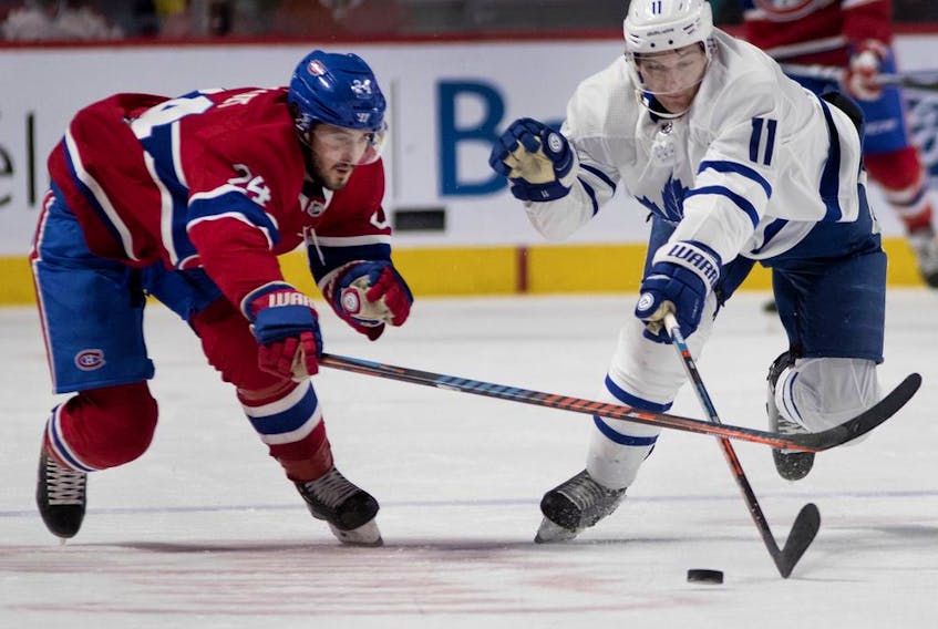 Canadiens centre Phillip Danault and Maple Leafs winger Zach Hyman race for the puck during action last season.