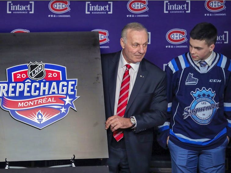 Hendrix Lapierre of the Chicoutimi Saguenéens watches as Montreal Canadiens legend Guy Lafleur unveils the logo for the National Hockey League draft prior to a game between the Canadiens and Arizona Coyotes in Montreal on Feb. 10 10, 2020. 