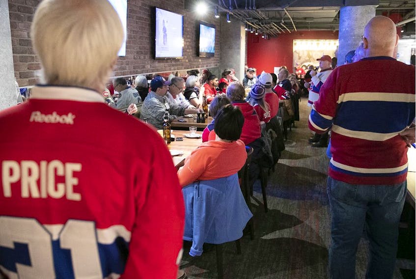  HI/O Summit organizer Ian Cobb (in white Canadiens sweater with red cap) addresses fans during lunch at La Cage Brasserie Sportive at the Bell Centre on Saturday, Nov. 16, 2019.