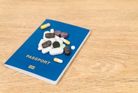 Stock image of a passport and pills for use with stories on portability of health care abroad or travel insurance.