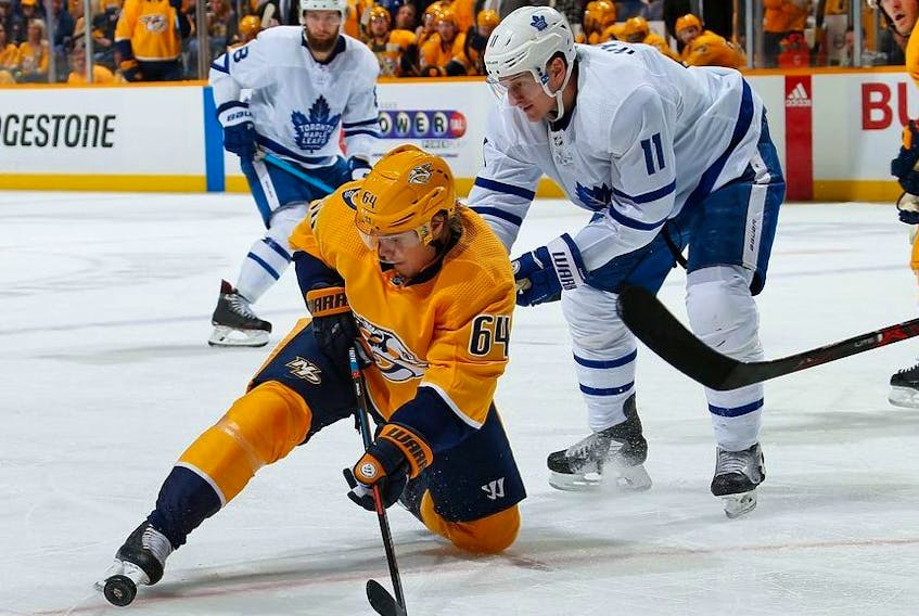 Mikael Granlund of the Nashville Predators gets his skate on a puck in front of Zach Hyman of the Toronto Maple Leafs during the second period at Bridgestone Arena on March 19, 2019 in Nashville, Tennessee.