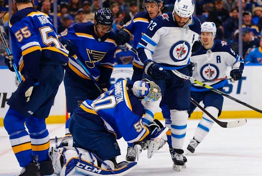 Jordan Binnington of the St. Louis Blues makes a save as Dustin Byfuglien of the Winnipeg Jets runs into him in Game Three of the Western Conference First Round during the 2019 NHL Stanley Cup Playoffs at the Enterprise Center on April 14, 2019 in St. Louis, Missouri.