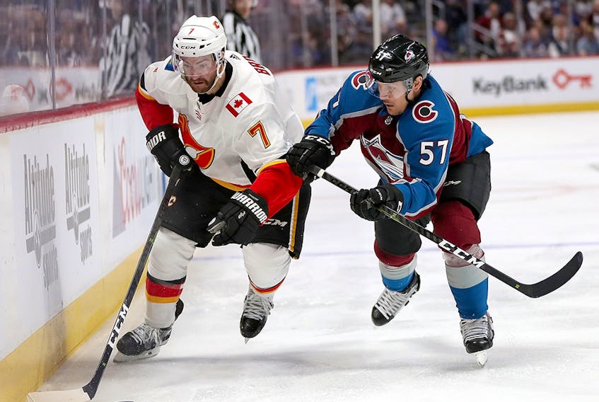  TJ Brodie #7 of the Calgary Flames fights on the boards with Gabriel Bourque #57 of the Colorado Avalanche in the third period during Game Three of the Western Conference First Round during the 2019 NHL Stanley Cup Playoffs at the Pepsi Center on April 15, 2019 in Denver, Colorado. (Photo by Matthew Stockman/Getty Images)