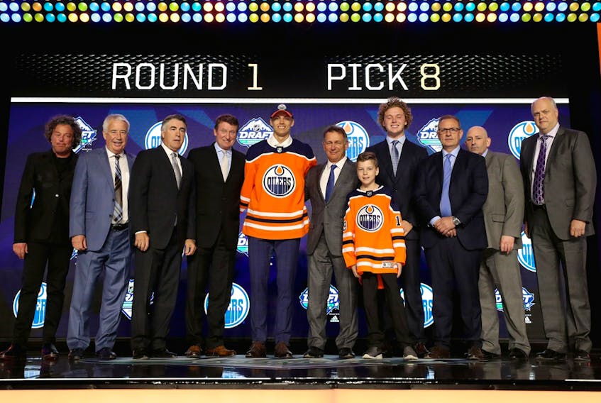 Edmonton Oilers owner Daryl Katz, left, and his son, Harrison, fourth from right, welcome the eighth-overall selection of the 2019 NHL Entry Draft in Vancouver on June 21, 2019. 