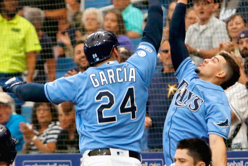 Avisail Garcia, left, of the Tampa Bay Rays and teammate Willy Adames celebrate with a high five after Garcia hit a two-run homer during the bottom of the eighth inning of their game against the Toronto Blue Jays at Tropicana Field on Sept. 8, 2019 in St. Petersburg, Fla. (Joseph Garnett Jr. /Getty Images)