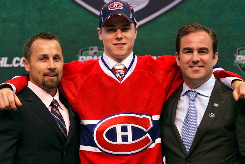Montreal Canadiens' 17th overall pick Nathan Beaulieu poses with director of procurement and player development Trevor Timmins and team owner Geoff Molson at the 2011 NHL Entry Draft in St. Paul, Minn., on June 24, 2011.