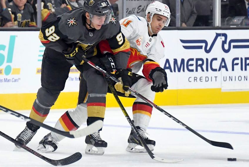 LAS VEGAS, NEVADA - OCTOBER 12:  Tomas Nosek #92 of the Vegas Golden Knights and Mikael Backlund #11 of the Calgary Flames fight for the puck in the second period of their game at T-Mobile Arena on October 12, 2019 in Las Vegas, Nevada. The Golden Knights defeated the Flames 6-2.