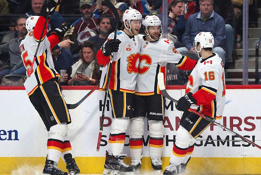  DENVER, COLORADO – DECEMBER 09: Noah Hanifin #55, Mark Jankowski #77, Michael Frolik #67 and Tobias Rieder #16 of the Calgary Flames celebrate a goal by Frolik against the Colorado Avalanche in the third period at the Pepsi Center on December 09, 2019 in Denver, Colorado. (Photo by Matthew Stockman/Getty Images)