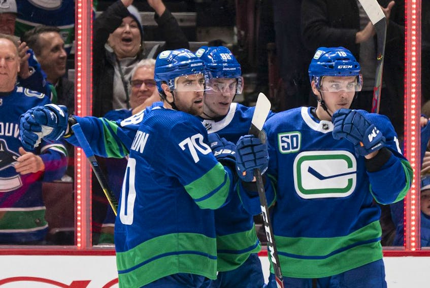 Tanner Pearson, left, Adam Gaudette and Jake Virtanen celebrate after scoring against the San Jose Sharks on Jan. 18, 2020 at Rogers Arena in Vancouver.
