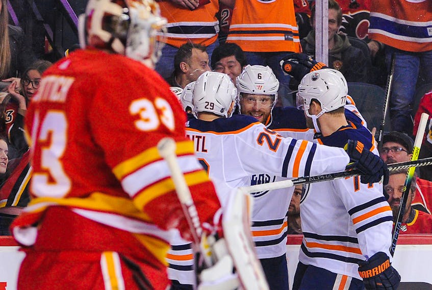 The Edmonton Oilers celebrate after their teammate, Kailer Yamamoto (not pictured) scored against David Rittich of the Calgary Flames, left, at Scotiabank Saddledome on Saturday, Feb. 1, 2020 in Calgary.