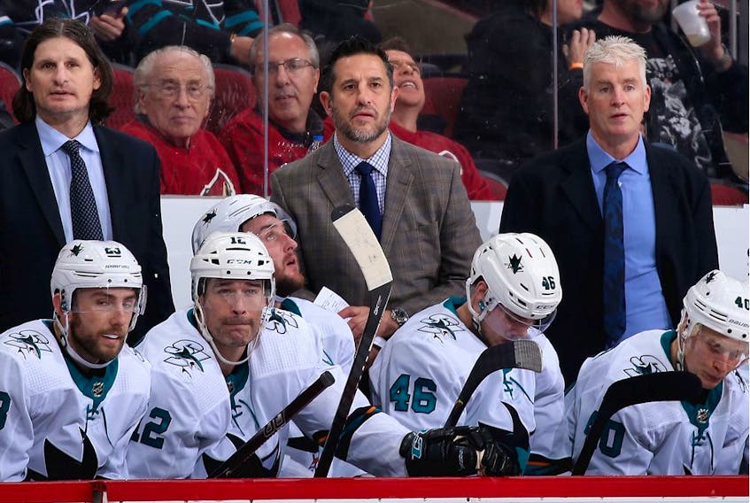 Coaches (top L-R) Mike Ricci, head coach Bob Boughner and Roy Sommer of the San Jose Sharks watch from the bench during the third period of the NHL game against the Arizona Coyotes at Gila River Arena on January 14, 2020 in Glendale, Arizona. The Coyotes defeated the Sharks 6-3.