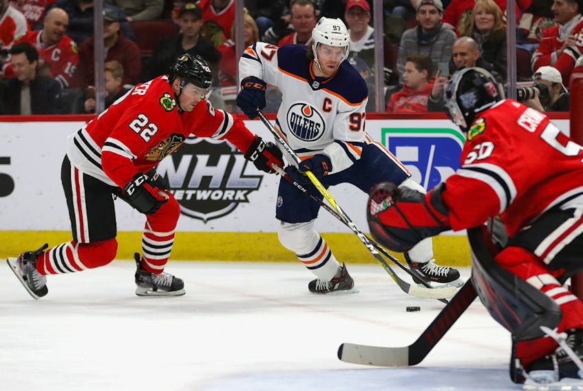 Connor McDavid (97) of the Edmonton Oilers tries to get off a shot against Corey Crawford (50) of the Chicago Blackhawks, but is pressured by Ryan Carpenter (22) at United Center on March 05, 2020, in Chicago. 