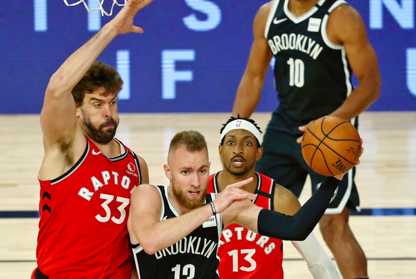 Dzanan Musa #13 of the Brooklyn Nets passes the ball while defended by Marc Gasol #33 of the Toronto Raptors  during the second half in Game 3 of the first round of the NBA playoffs at The Field House at ESPN Wide World Of Sports Complex on Friday. 
