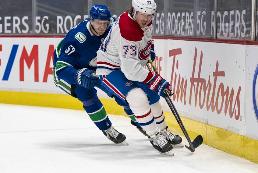 Canadiens' Tyler Toffoli picks up the loose puck while being chased by Canucks' Tyler Myers Wednesday night at Rogers Arena in Vancouver.