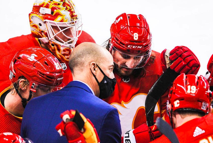 CALGARY, AB - FEBRUARY 9: Assistant coach Ryan Huska of the Calgary Flames talks with Joakim Nordstrom #20, Jacob Markstrom #25, Christopher Tanev #8, Mikael Backlund #11 and Matthew Tkachuk #19 during a time-out in an NHL game against the Winnipeg Jets at Scotiabank Saddledome on February 9, 2021 in Calgary, Alberta, Canada.