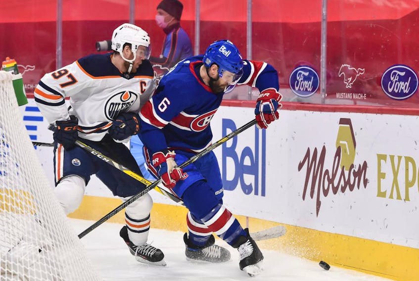 Connor McDavid #97 of the Edmonton Oilers and Shea Weber #6 of the Montreal Canadiens chase the puck during the first period at the Bell Centre on February 11, 2021.