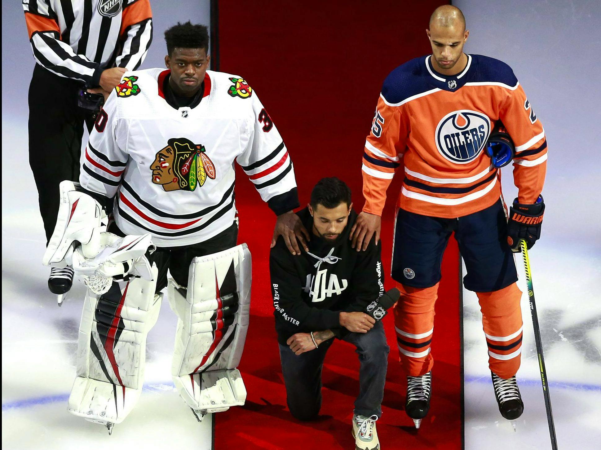 Matt Dumba of the wild is flanked by Blackhawks goalie Malcolm Subban and Oilers’ Darnell Nurse during the U.S. anthem prior to a playoff game at Edmonton in August.                 
