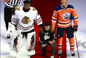 Matt Dumba of the wild is flanked by Blackhawks goalie Malcolm Subban and Oilers’ Darnell Nurse during the U.S. anthem prior to a playoff game at Edmonton in August.                 