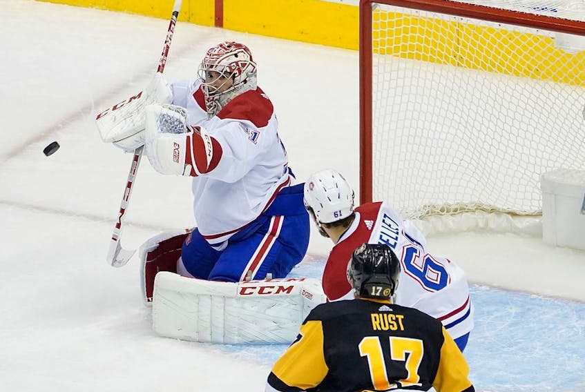 Canadiens goalie Carey Price makes one of his 35 saves as Habs defenceman Xavier Ouellet battles Penguins' Bryan Rust in front of the net Monday night. 