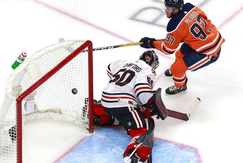 Connor McDavid of the Oilers scores his second goal against Corey Crawford of the Chicago Blackhawks during the first period in Game 2 of the Western Conference qualification round before the Stanley Cup playoffs, at Rogers Place on Aug. 3 in Edmonton.