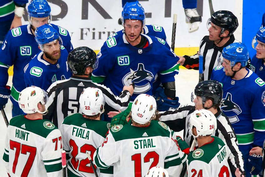 Jay Beagle of the Vancouver Canucks exchanges words with Eric Staal of the Minnesota Wild during a Game 2 scrum at Rogers Place in Edmonton on Tuesday night.
