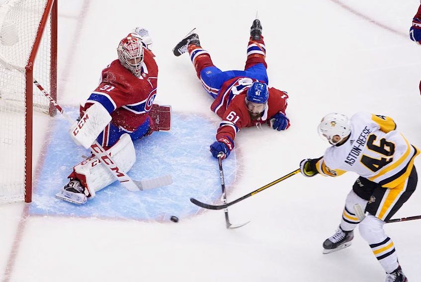 Canadiens' Carey Price stymies Penguins' Zach Aston-Reese after defenceman Xavier Ouellet made a diving attempt to alter the shot. 