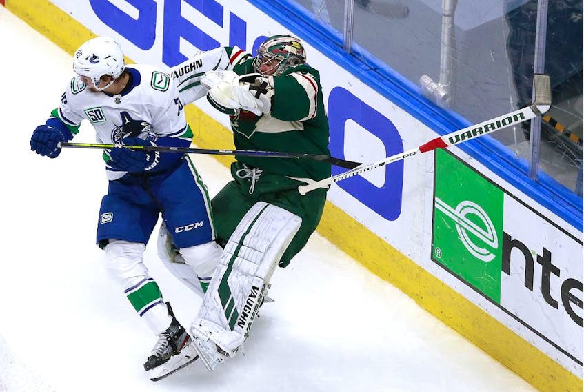  Antoine Roussel of the Vancouver Canucks collides with netminder Alex Stalock of the Minnesota Wild during Thursday’s NHL action in Edmonton.