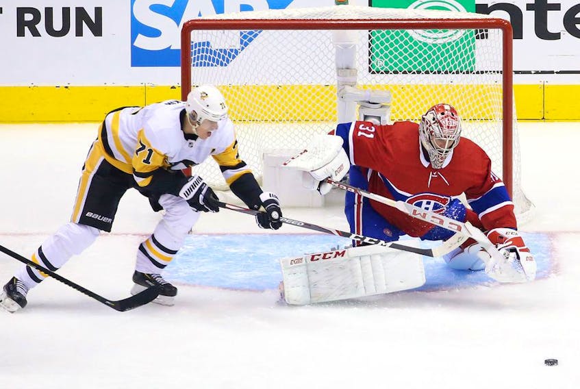 Canadiens goalie Carey Price makes a save while Penguins star Evegeni Malkin lurks around the net during Game 4 of the team's qualification-round series last week. Price was outstanding, posting a 1.67 goals-against average and a .947 save percentage in the series.