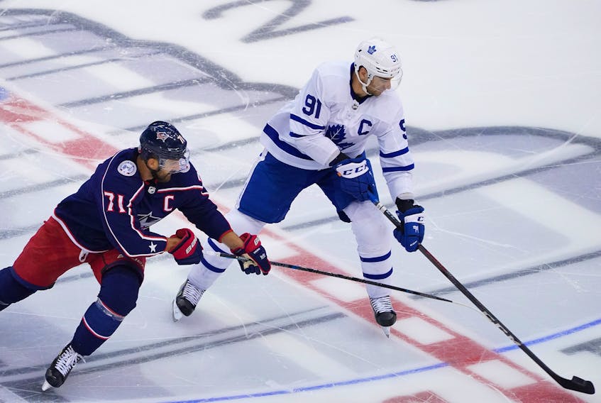 John Tavares of the Toronto Maple Leafs plays the puck against Nick Foligno of the Columbus Blue Jackets in Game Four of the Eastern Conference Qualification Round prior to the 2020 NHL Stanley Cup Playoffs at Scotiabank Arena on August 07, 2020 in Toronto, Ontario. 